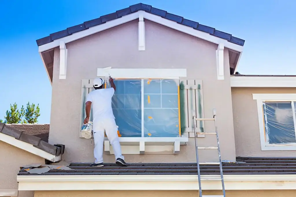 House painter in Sebastian, FL, painting the exterior trim of a coastal-style home.