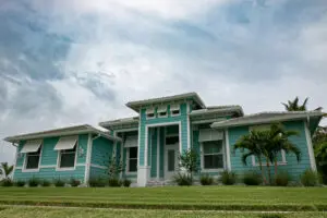 Teal coastal-style Cocoa Beach home showing exterior paint affected by summer weather conditions